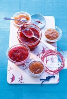 Three bowls of rhubarb and orange jam, two bowls with rhubarb and raspberry jam