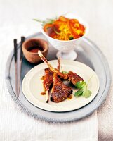 Lamb chops and bowl of Asian lentil salad on plate