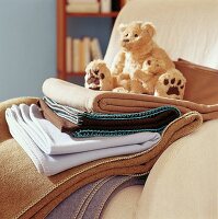 Teddy auf Decken, Sessel in beige gemütlich, winterlich