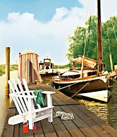 Bootssteg mit weißem Gartenstuhl Strandkabine und Booten