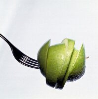 Close-up of green apple slices on fork