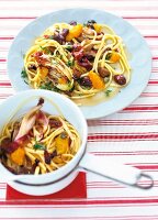Linguine with Radicchio, orange and olive served on white plate and sauce pan