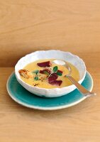 Polenta soup with smoked duck breast in bowl