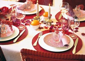 Decorated red dinning table with lit candles and petals