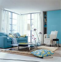 Blue sofa, table, armchairs, side lamp and cushion in living room
