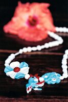 Plastic chain with kakadu vogel and red glitter flower