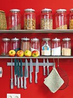 Knife hanging from magnetic bar under shelf with preserving jars