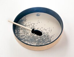 Ocean drum with small metal balls on white background