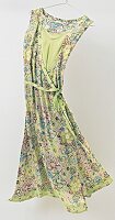 Floral pattern green viscose summer dress hanging on coat hanger