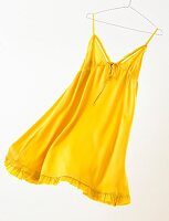 Yellow summer dress hanging on coat hanger