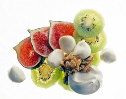 Mozzarella, walnut and slices of fig and kiwi against white background