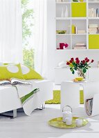 Living room decorated in green and white with sofa, cushion, table and bookshelf