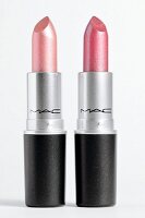 Close-up of lipsticks with metallic effect on white background