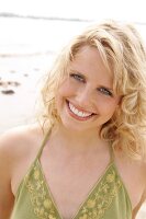 Berit,  Frau mit grünem Sonnentop am Strand, lacht in die Kamera