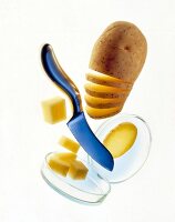 Ungeschälte angeschnittene Kartoffel + Messer + Kartoffelwürfel in Dose