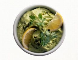 Green pasta sauce with coriander and lemon in bowl