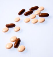 Close-up of oval and round pills on white background