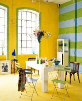 Bright dining room in yellow with dining table and folding chairs