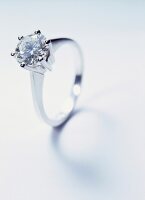 Close-up of white gold ring with diamond on white background