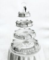 White wedding cake with four layers at top bridal couple figurine, black and white