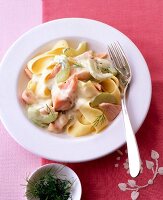 Pasta with salmon and cucumber sauce on plate