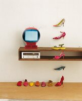 Colourful shoes on floor, shelf and stuck on white wall