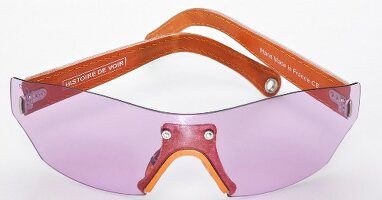 Close-up of pink sunglasses with leather temples on white background