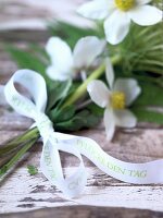 Close-up of white ribbon with quote attached to bouquet