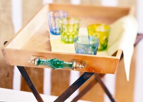 Four glasses kept on wooden tray
