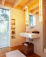 Helles Badezimmer mit Waschbecken, Wandelement verbirgt WC u. Dusche