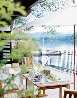 Gedeckter Tisch auf der Terrasse mit Blick auf den Wörthersee