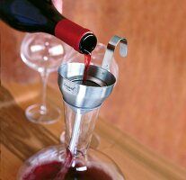 Rotwein wird durch e. Trichter aus Edelstahl gegossen: Dekantieren
