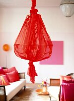 Chandelier hanging on ceiling wrapped in red cloth