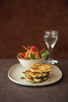 Buckwheat biscuits with bowl of salad on plate