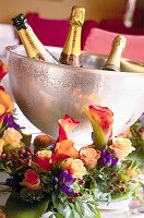 3 Flaschen Champagner im Eiskübel, dekoriert mit Blumen.
