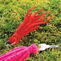 Schlüsselanhänger mit Fransen in Rot und Pink auf Moos