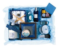 Geschenk-Sortiment: Beauty-Produkte auf blauem Seidenpapier