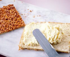 Cream applied on nut cake with pie knife