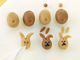 Rabbit head shaped marzipans being painted with chocolate
