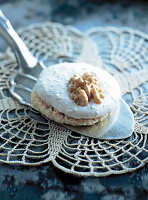 Close-up of walnut meringue with walnut on cake server