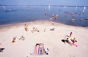 Tourists sunbathing on lakeshore of Steinhuder Meer, Steinhude, Germany