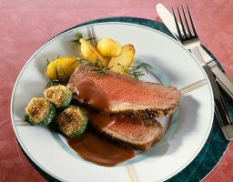 Roasted beef with red wine sauce and zucchini on plate