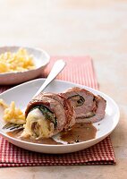 Veal rolls with cheese and ham on plate and fork