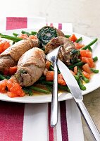 Close-up of involtini with spinach on white plate