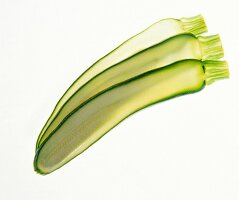 Zucchini cut lengthwise in thin slices on white background