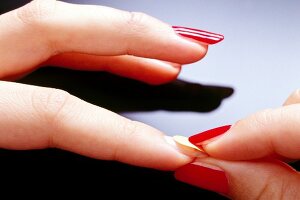 Close-up of woman sticking artificial nails, step 2