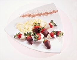 Strawberries dipped in white and dark chocolate with lemon peels on plate