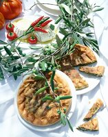 Italian frittata and soft cheese decorated with olive branches on plates