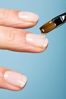 Close-up of woman applying gel on nails with brush