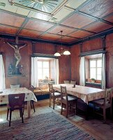 Gaststätte mit Tischen und Bänken Holzkreuz mit Kruzifix an der Wand